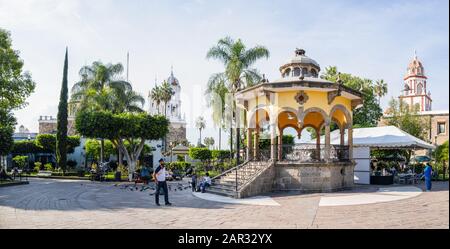 San Pedro Tlaquepaque, Jalisco, Messico - 23 novembre 2019: Vista sul giardino di hidalgo ed è chiosco, con la nostra signora di Solitude, e San Pietro LA A. Foto Stock