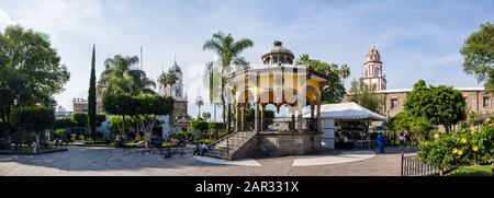 San Pedro Tlaquepaque, Jalisco, Messico - 23 novembre 2019: Vista sul giardino di hidalgo ed è chiosco, con la nostra signora di Solitude, e San Pietro LA A. Foto Stock