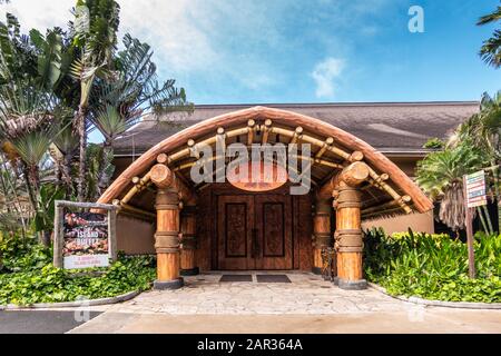 Laie, Oahu, Hawaii, Stati Uniti. - 09 Gennaio 2020: Centro Culturale Polinesiano. Grande entrata in legno al ristorante Island buffet sotto il cielo blu con molto Foto Stock