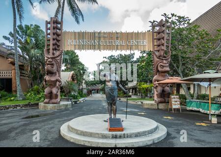 Laie, Oahu, Hawaii, Stati Uniti. - 09 Gennaio 2020: Centro Culturale Polinesiano. Statua in bronzo di Hamana Kalili che dà il segno Shaka di fronte al monumentale e Foto Stock