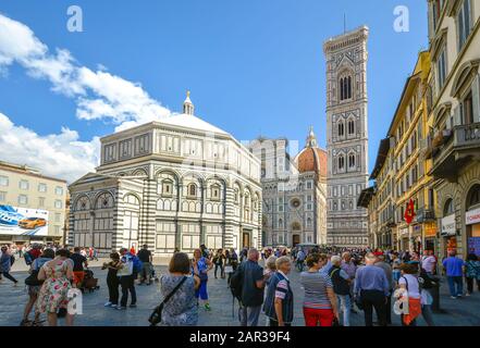 La cattedrale o il duomo di Firenze insieme al Battistero e al Campanile di Giotto con i turisti in piazza in una giornata piena di sole e affollate in Toscana. Foto Stock