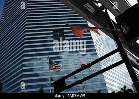 Vista dell'edificio della Miami Tower nel centro di Miami con bandiere e tracce Metromover nella cornice Foto Stock