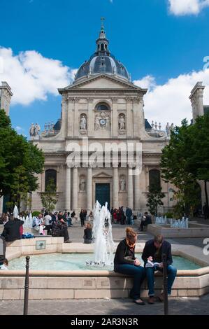 Coppia seduta da una fontana vicino all'Università della Sorbona, Parigi Foto Stock