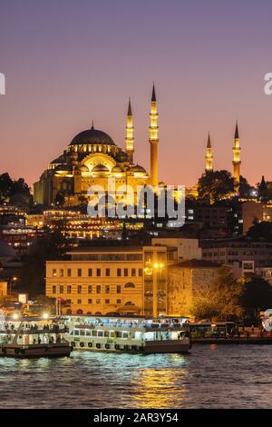 Moschea Suleymaniye e barche turistiche al crepuscolo a Istanbul, Turchia Foto Stock