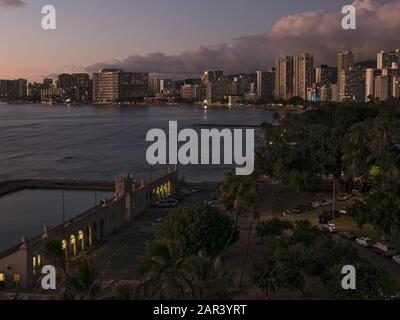 Honolulu, Hawaii, Stati Uniti. 15th dicembre 2019. Una vista panoramica ad alto angolo al tramonto del Parco Kapiolani e degli hotel di alto livello lungo il litorale di Waikiki. In primo piano (a sinistra) è il Natatorium War Memorial, una piscina di acqua salata 1920s sul Registro Nazionale dei luoghi storici, ma non più in uso. Credito: Bayne Stanley/Zuma Wire/Alamy Live News Foto Stock