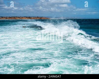 Mare mosso che smashing sulla barriera corallina e il molo di Port Noarlunga in Australia del sud il 23rd gennaio 2020 Foto Stock