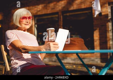 Donna anziana pensierosa che si gode la sua mattina sola Foto Stock