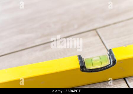 Primo piano colpo di un metallo giallo livella posto su una nuova installazione ancora non finito piastrelle da cucina Foto Stock