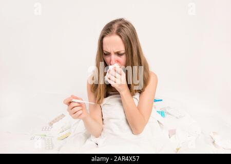 Ritratto di donna malata con febbre e termometro con naso che regge Foto Stock