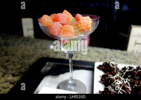 Pasticche di Frutta morbida e masticabile in una Champagne Coupe in vetro trasparente in esposizione al buffet presso l'Azul Beach Resort Hotel, Puerto Morelos, Riviera Maya. Foto Stock