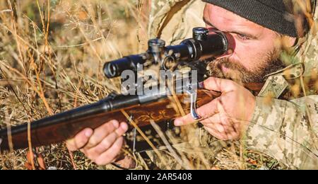 Uomo cacciatore con fucile pistola. Boot camp. Uomo Barbuto hunter. Forze armate. Il camuffamento. Uniforme militare di moda. Abilità di caccia e di apparecchiature di arma. Come ruotare la caccia in hobby. Strict verdetto. Foto Stock