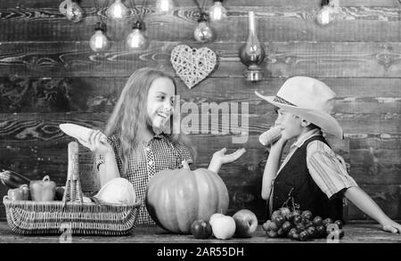 Responsabile delle faccende agricole quotidiane. Bambini agricoltori ragazza ragazzo verdure raccolto. Fattoria di famiglia. Bambini che presentano la fattoria raccolto sfondo di legno. Motivi per cui ogni bambino dovrebbe sperimentare l'agricoltura. Foto Stock