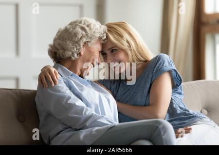 Amante giovane signora godendo dolce momento tenero con madre più anziana. Foto Stock