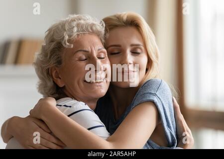 Affettuosa famiglia di due generazioni femminili che gode dolce momento tenero. Foto Stock