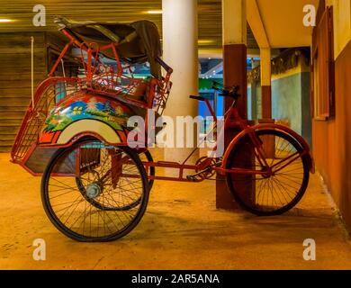 Ricksha rosso vintage, risciò a ciclo tradizionale, veicolo di trasporto vintage dall'Asia Foto Stock