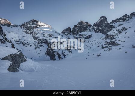 Lago Ghiacciato E Spaventoso di fronte alle vette di Kupens nel parco nazionale della montagna di Rila, regione di Malyovitsa, Bulgaria Foto Stock