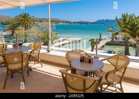 Mallorca, SPAGNA - 6 maggio 2019: Un ristorante che si affaccia sulla baia e sulla spiaggia di Port de Pollenca a Maiorca Foto Stock