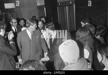 John Lennon e moglie Yoko Ono lasciate l'Hilton Hotel ad Amsterdam, circondato da persone di sicurezza Data: 31 Marzo 1969 posizione: Amsterdam, Noord-Holland Parole Chiave: Arrivo e partenza, coppie, musicisti Nome personale: Lennon, John, Ono, Yoko Foto Stock