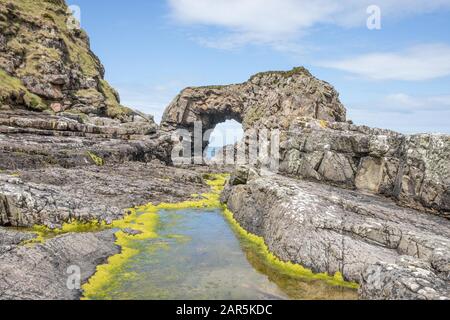 Bellissimo scatto di un affioramento e colline rocciose circondato da acqua Foto Stock