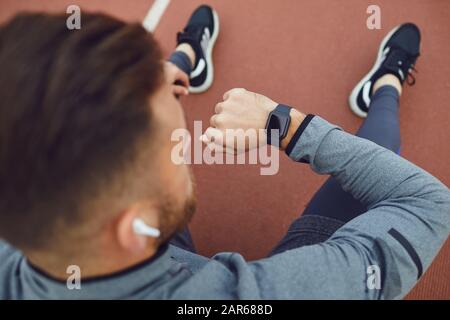 Top view.Hands di un atleta maschio in cuffie ad uno stadio. Foto Stock