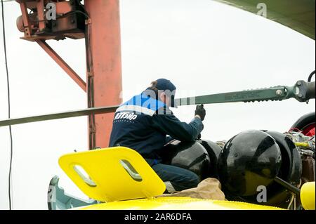 Meccanico maschio in uniforme esaminando elicottero Foto Stock