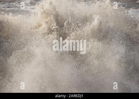 Onde alte, demolitori da come canale tempesta con montato su spiaggia sabbia erodendo la costa su Hive Beach, Dorset, gennaio Foto Stock