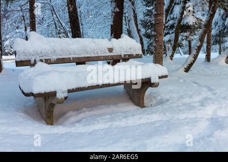 Snowy Bench al Lago Jasna in inverno vicino Kranjska Gora, Slovenia. Foto Stock