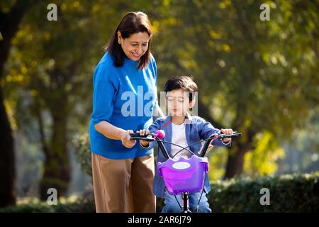 Nonna con nipote imparare a guidare la bicicletta Foto Stock