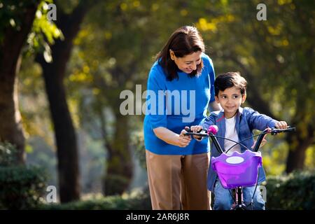 Nonna con nipote imparare a guidare la bicicletta Foto Stock