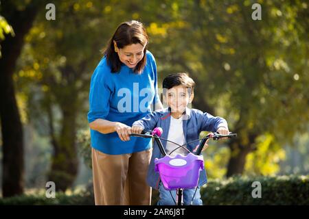 Nonna con nipote imparare a guidare la bicicletta Foto Stock