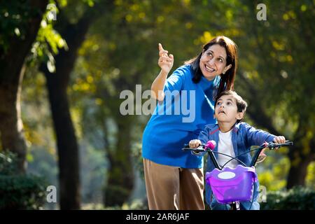 Nonna con nipote imparare a guidare la bicicletta Foto Stock