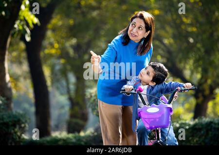 Nonna con nipote imparare a guidare la bicicletta Foto Stock