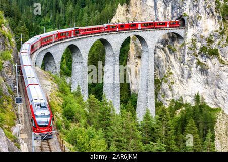 Viadotto Landwasser A Filisur, Svizzera. E' famoso punto di riferimento della Svizzera. Treno espresso rosso su ponte alto in montagna. Vista panoramica su una ferrovia incredibile Foto Stock