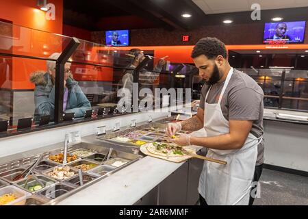 Detroit, Michigan - un lavoratore fa una pizza al Flamz Pizzeria nel quartiere Morningside della città. Il ristorante offre pizze wi su ordinazione Foto Stock