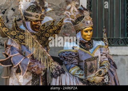 Fantasiosa maschera in splendido costume al carnevale di Venezia. Le persone dietro non sono più riconoscibili e celebrare il carnevale tradizionale di Foto Stock