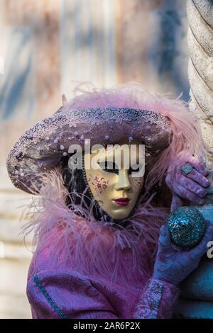 Fantasiosa maschera in splendido costume al carnevale di Venezia. Le persone dietro non sono più riconoscibili e celebrare il carnevale tradizionale di Foto Stock