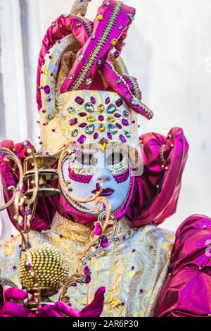 Fantasiosa maschera in splendido costume al carnevale di Venezia. Le persone dietro non sono più riconoscibili e celebrare il carnevale tradizionale di Foto Stock