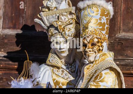 Fantasiosa maschera in splendido costume al carnevale di Venezia. Le persone dietro non sono più riconoscibili e celebrare il carnevale tradizionale di Foto Stock