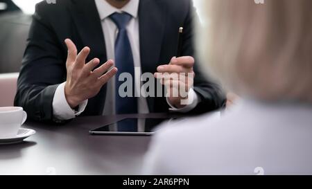 Primo piano uomo d'affari che tiene la penna, spiegando le idee di offerta ai soci. Foto Stock