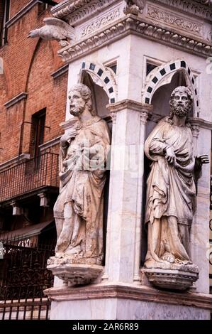 Statue adornano la loggia marmorea o cappella, la Cappella di Piazza, alla base della Torre del Mangia a Siena. Foto Stock