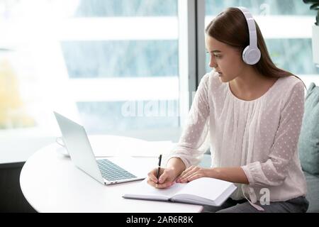 Donna millenaria motivata che studia in remoto nell'università in linea. Foto Stock