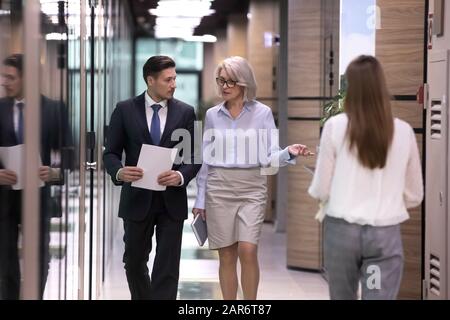 Diverse età si sono focalizzati lavoratori aziendali internazionali a piedi nel corridoio. Foto Stock