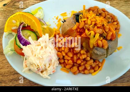 A buon mercato sano pranzo camicia di patate con formaggio di fagioli coleslaw ed insalata Foto Stock