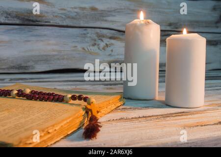 la bibbia con perle e grandi candele. Foto Stock