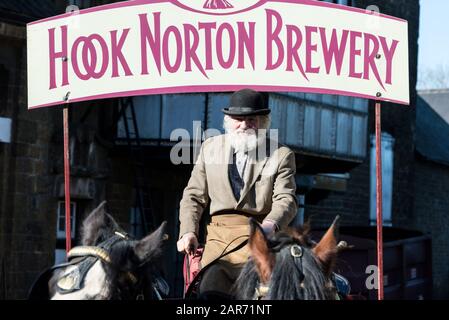 Drayman, Roger Hughes guida i suoi cavalli Shire e dray alla famiglia ganci di proprietà Norton Brewery fondata nel 1849, nel villaggio di Hook Norton villaggio Foto Stock