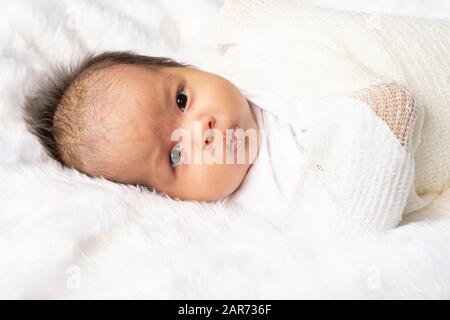 Carino neonato ragazza nella coltre bianca sul letto di vivaio. Adorabili nuovo nato bambino, Little Boy occhi guardano persone famiglia, nuova infanzia, infantili soft skin p Foto Stock