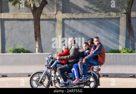 Cairo / Egitto - Dicembre, 2015: Padre e cinque bambini viaggiano pericolosamente in moto Foto Stock