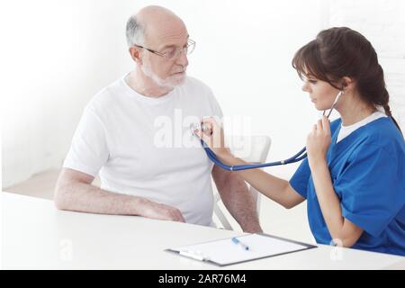 Assistenza sanitaria, anziani e medicina, medico con stetoscopio che ascolta il respiro o il battito cardiaco degli anziani in ospedale Foto Stock