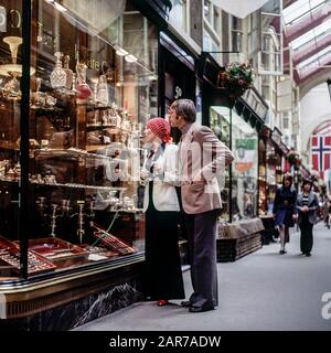 Londra 1970, elegante coppia matura per lo shopping di stoviglie, Burlington Arcade, Piccadilly, Mayfair, Inghilterra, Regno Unito, Regno Unito, Gran Bretagna, Foto Stock