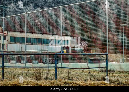 campo da calcio invernale con montagne ghiacciate in background e gol Foto Stock